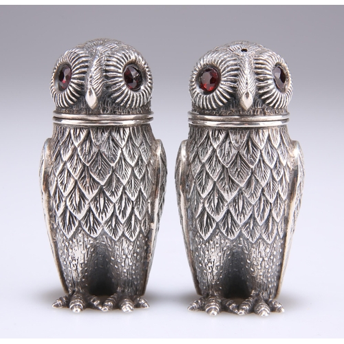 1046 - A PAIR OF WHITE METAL NOVELTY PEPPER POTS, each stamped '925' and in the form of an owl, with facet-... 