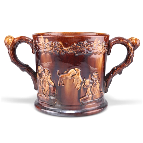 149 - A 19TH CENTURY LARGE STAFFORDSHIRE TREACLE GLAZE LOVING CUP, moulded decoration depicting tavern sce... 