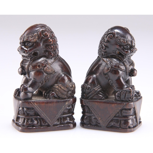 293 - A PAIR OF CHINESE CARVED HARDWOOD MODELS OF TEMPLE DOGS, each signed. (2) 5.3cm high