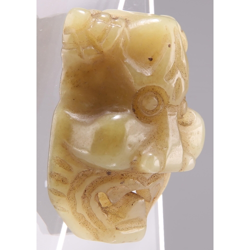 316 - A CHINESE CARVED JADE BELT BUCKLE, carved and pierced in the form of a mask, with an open mouth. 5.5... 