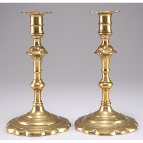 341 - A PAIR OF 18TH CENTURY BRASS PETAL-BASE CANDLESTICKS, each with knopped stem. (2) 19.5cm high