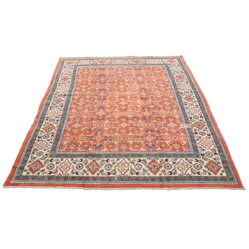 464 - A TURKISH CARPET, CIRCA 1970, the orange field with all-over design of flowerheads and sprays, the b... 