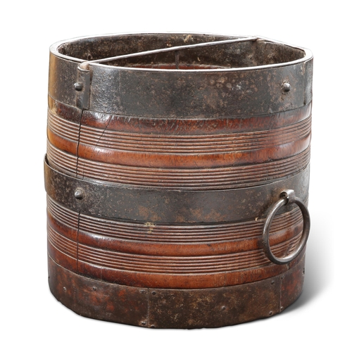 506 - A 19TH CENTURY INDIAN IRON-MOUNTED TEAK GRAIN MEASURE, cylindrical with reeded bands and large loop ... 