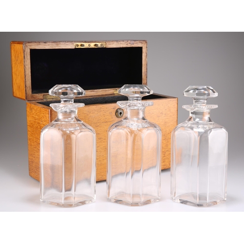 510 - A VICTORIAN OAK DECANTER CASE, the rectangular box with hinged cover and Bramah lock, containing thr... 