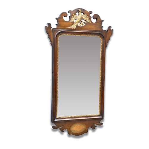 552 - A GEORGIAN STYLE INLAID MAHOGANY FRETWORK MIRROR, the crest carved with a phoenix, the apron with sh... 