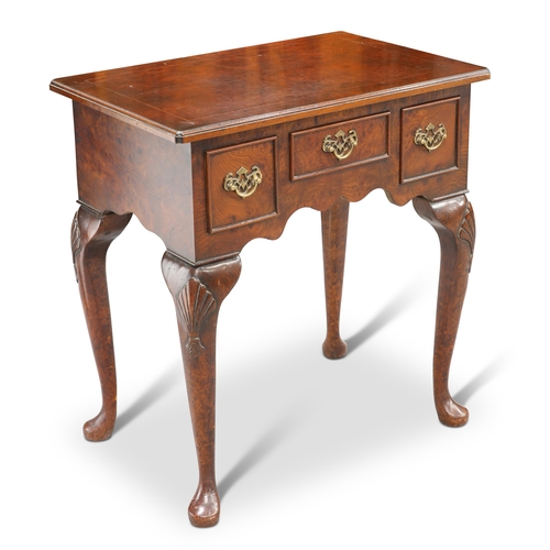 557 - A GEORGIAN STYLE YEW WOOD LOWBOY, the moulded rectangular top with inverted corners above three frie... 