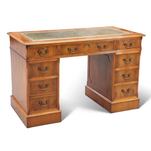 558 - A GEORGIAN STYLE YEW WOOD PEDESTAL DESK, the moulded rectangular top with green tooled leather-inset... 