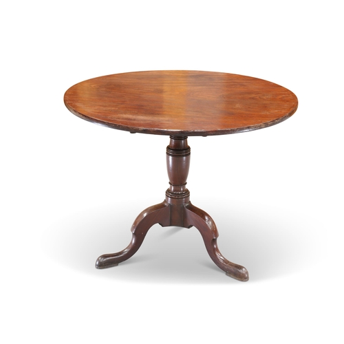 564 - A GEORGE III MAHOGANY TILT-TOP TRIPOD TABLE, the circular top raised on a vasi-form stem continuing ... 