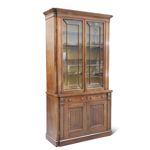 610 - AN EARLY 19TH CENTURY MAHOGANY BREAKFRONT BOOKCASE, CIRCA 1825, the upper section with a pair of ast... 