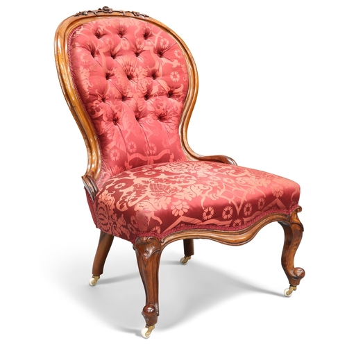 652 - A VICTORIAN WALNUT AND UPHOLSTERED NURSING CHAIR, the spoon-shaped back with carved foliate crest an... 