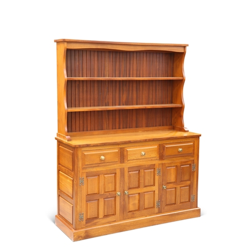 702 - A CRYER CRAFT ELM DRESSER AND RACK, the rack with two fixed shelves, the base with three drawers ove... 