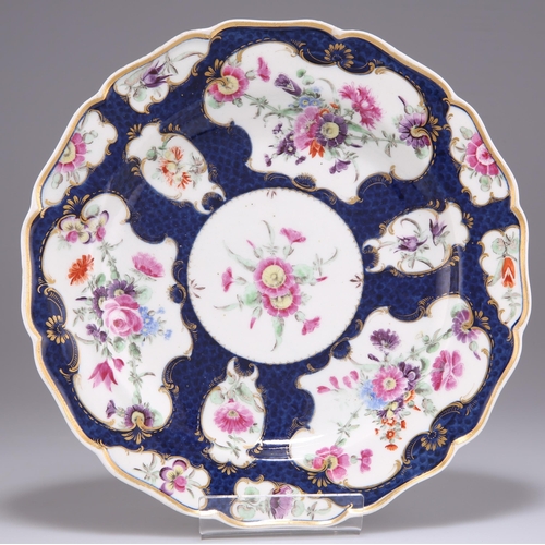 79 - A WORCESTER PORCELAIN DESSERT PLATE, CIRCA 1770, with a lobed edge and decorated with reserves of fl... 