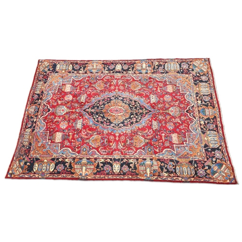 455 - A LARGE PERSIAN KASHAN CARPET, hand-knotted, the raspberry field with large scalloped dark blue meda... 