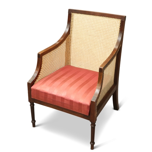 671 - A REGENCY STYLE MAHOGANY AND CANEWORK BERGÈRE, CIRCA 1900, with drop-in seat and fluted forelegs. He... 