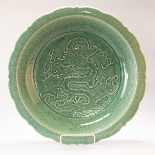 120 - A LARGE CHINESE CELADON DRAGON DISH, with lotus petal rim, the well depicting a four-toed dragon abo... 