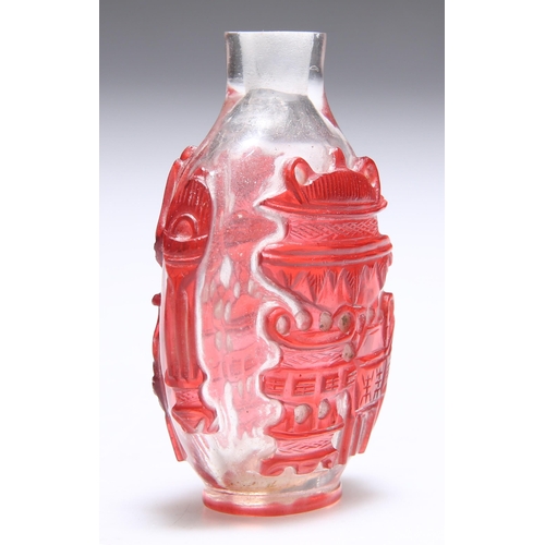 152 - A CHINESE RED OVERLAY SNUFF BOTTLE, carved with censers and other objects. 6.2cm high... 