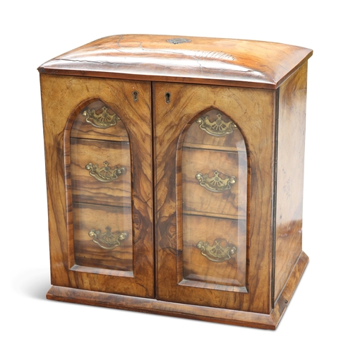 485 - A VICTORIAN WALNUT TABLE CABINET, the glazed doors reveal three graduated drawers with brass handles... 