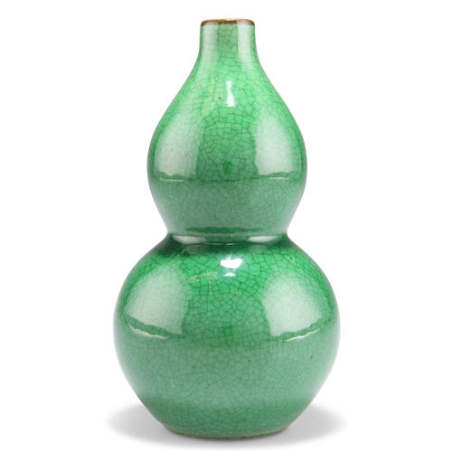 125 - A CHINESE MONOCHROME APPLE-GREEN GOURD VASE, with crackle glaze. 14cm high