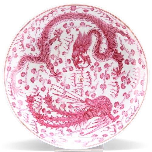 126 - A CHINESE PUCE DECORATED 'DRAGON AND PHOENIX' DISH, boldly decorated with a writhing five-clawed dra... 