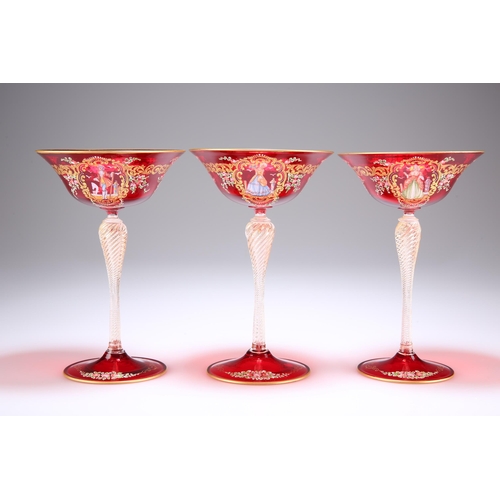 14 - A SET OF THREE VENETIAN RUBY GLASS CHAMPAGNE COUPES, with dish bowls on wrythen baluster stems and d... 