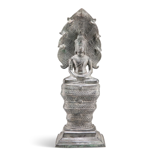 145 - A LATE 18TH / EARLY 19TH CENTURY CAMBODIAN BRONZE GAUTAMA BUDDAH, modelled seated uner the cobra Muc... 