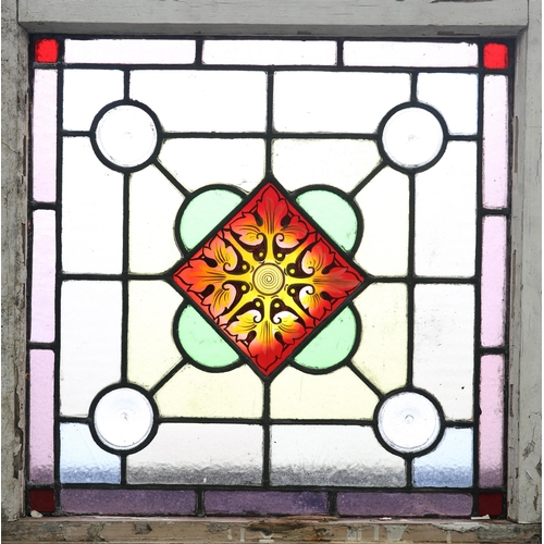 181 - A LEADED STAINED GLASS WINDOW, a central red and yellow foliate pane surrounded by yellow glass, wit... 