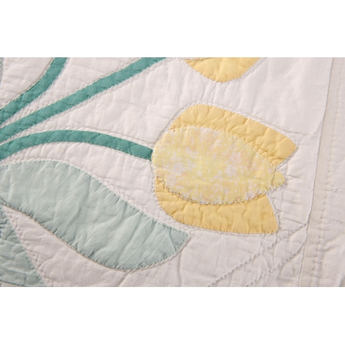 204 - A VINTAGE DURHAM QUILT, decorated with flowers within a pale blue border. 222cm by 186cm... 