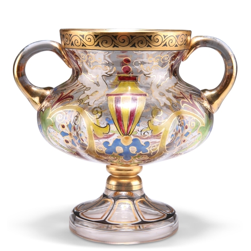 26 - A BOHEMIAN STEINSCHONAU ART NOUVEAU TWO-HANDLED GLASS CUP, of lobed pedestal form, painted in colour... 