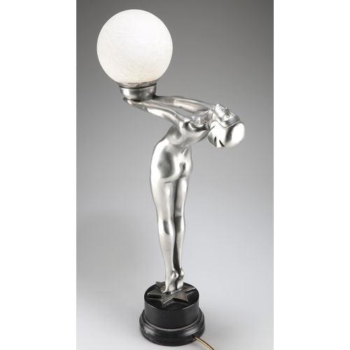 299 - AN ART DECO STYLE PATINATED FIGURAL TABLE LAMP, the sinuous figure modelled holding aloft a globe, o... 