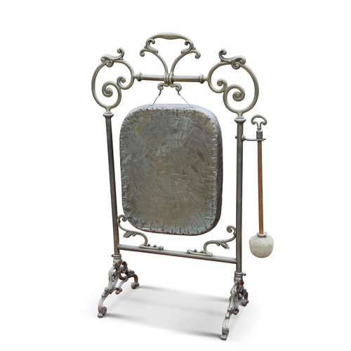 48 - AN EDWARDIAN BRASS DINNER GONG, with scroll-form frame, complete with beater. 80cm high... 