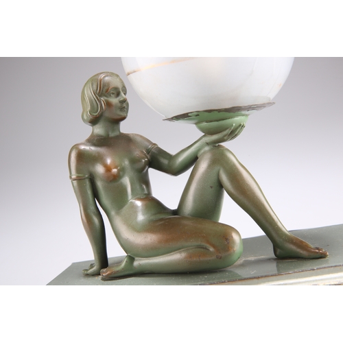 295 - AN ART DECO PATINATED SPELTER FIGURAL TABLE LAMP, modelled as a reclining female resting a frosted a... 