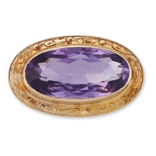 1788 - AN AMETHYST BROOCH an oval-cut amethyst in a foliate scroll engraved frame. 1.6cm by 2.7cm, marked '... 