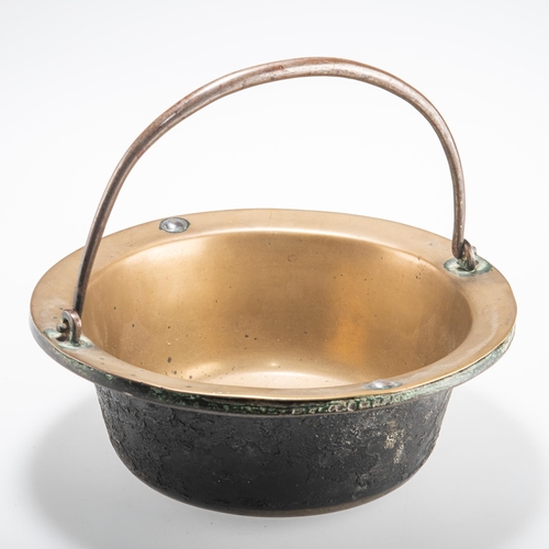 61 - A SMALL 18TH CENTURY BRASS AND IRON PAN with swing-handle. 24cm diameter