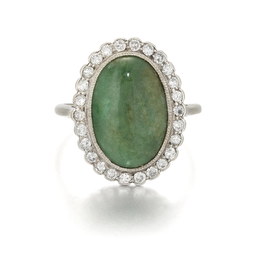 1692 - AN EARLY 20TH CENTURY JADE AND DIAMOND CLUSTER RING an oval jade within a milgrain border of old-cut... 