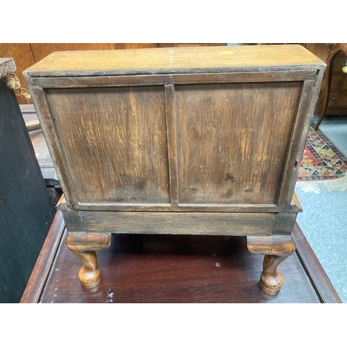 884 - AN 18TH CENTURY STYLE OAK MINIATURE BUREAU with fitted interior and drawer, raised on an integral st... 