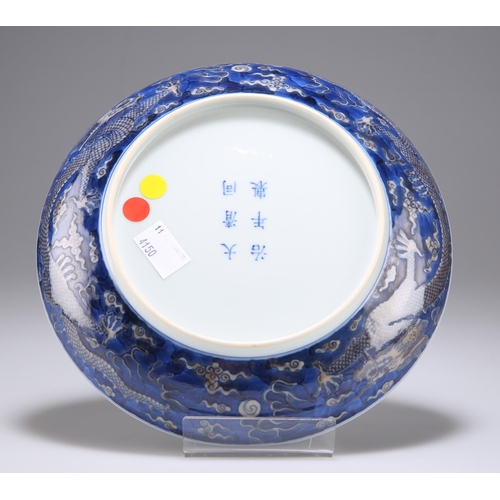 125 - A CHINESE DRAGON DISH circular, decorated with three dragons and blue-glazed, bears underglaze blue ... 