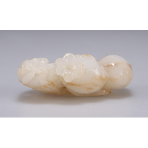 137 - A CHINESE JADE CARVING in open work to depict peaches and leaves on a branch. 6.5cm wide