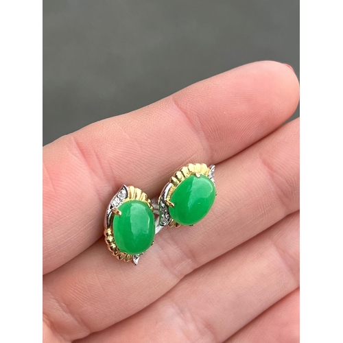 415 - A PAIR OF BI-COLOUR JADE AND DIAMOND EARRINGS oval jade within bi-colour fancy frames with diamond a... 