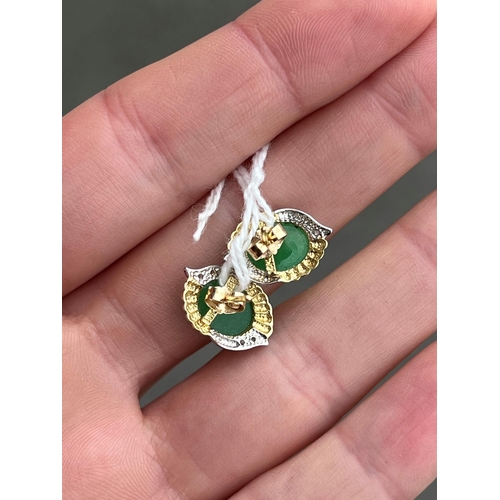 415 - A PAIR OF BI-COLOUR JADE AND DIAMOND EARRINGS oval jade within bi-colour fancy frames with diamond a... 