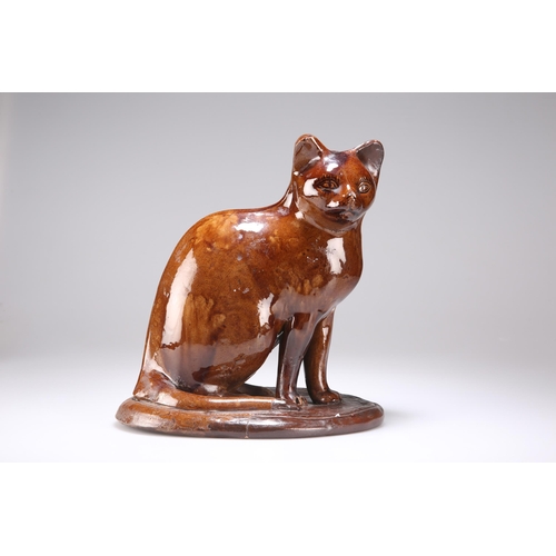 94 - A CANNEY HILL POTTERY CAT 19th Century, brown-glazed, seated on an integral oval plinth. 27cm highTh... 