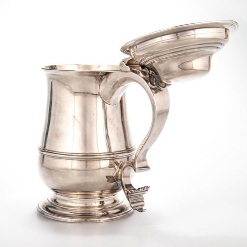 227 - AN EARLY GEORGE III SILVER LIDDED TANKARD maker I*M, London 1765, of baluster form, the hinged domed... 