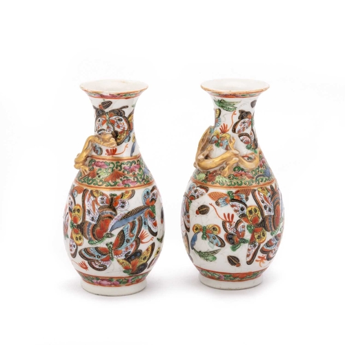 122 - V A PAIR OF CHINESE FAMILLE ROSE VASES each enamel painted with butterflies and foliate borders, bot... 