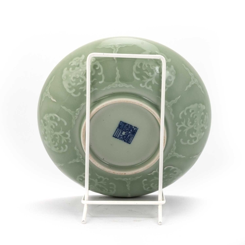 124 - A CHINESE CELADON-BACK FAMILLE ROSE DISH circular, painted with flowers, bats and tendrils to the ce... 