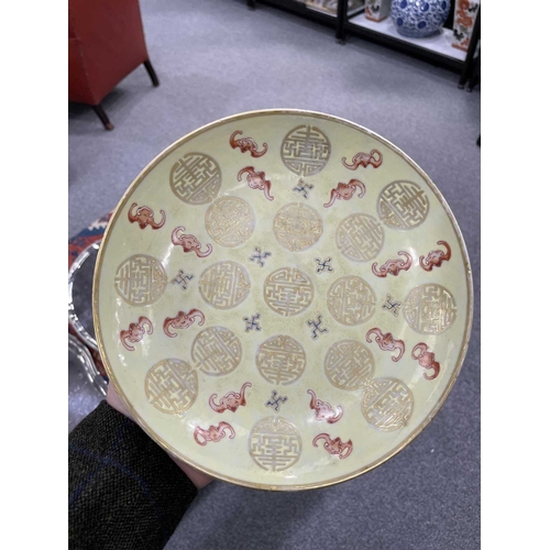 180 - A FAMILLE ROSE AND GILT-DECORATED YELLOW-GROUND DISH with rounded sides, decorated on the interior w... 