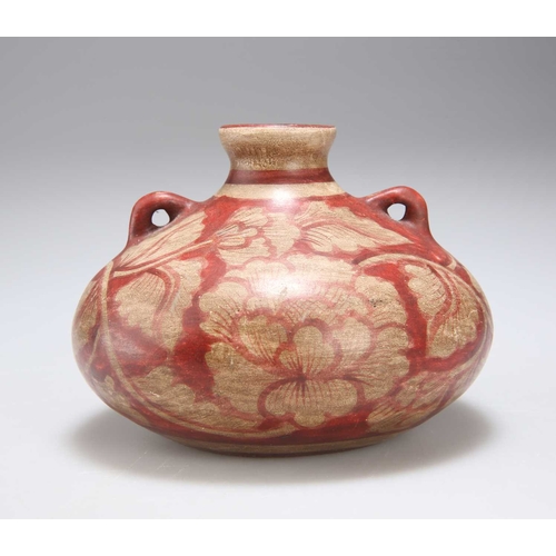 227 - A CHINESE CIZHOU VASE of compressed form, painted in red with peony flowers, two small loop handles ... 