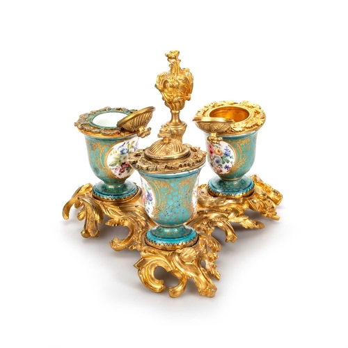 51 - A SÈVRES PORCELAIN AND ORMOLU THREE-BOTTLE INKSTAND the Sèvres bottles painted with flowers, on a bo... 