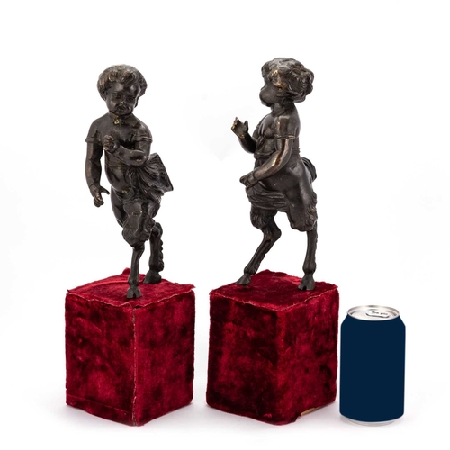 630 - A PAIR OF 19TH CENTURY BRONZE CHERUBIC FAUNS once forming part of a candelabra, raised on velvet pli... 