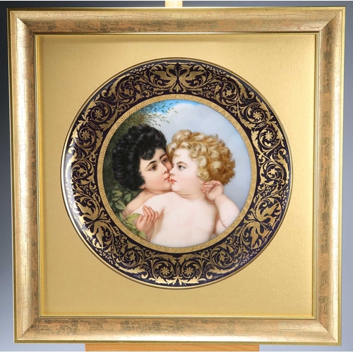 68 - A LARGE VIENNA PLAQUE, LATE 19TH CENTURY painted with embracing putti, the broad cobalt border richl... 