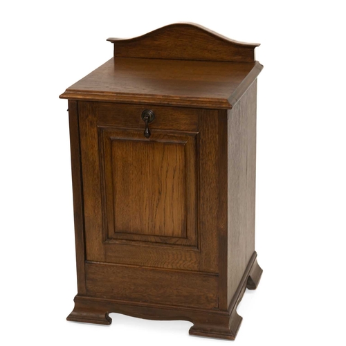 784 - AN ARTS AND CRAFTS OAK COAL BOX with an arched backboard and hinged panel-front, raised on splayed b... 