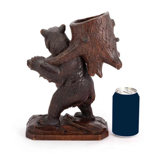 809 - A BLACK FOREST NOVELTY SPILL HOLDER, LATE 19TH CENTURY carved as a bear carrying a hollowed section ... 